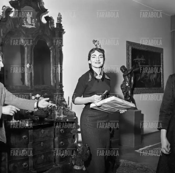 Maria Callas scarta un regalo in casa, Milano, 1955