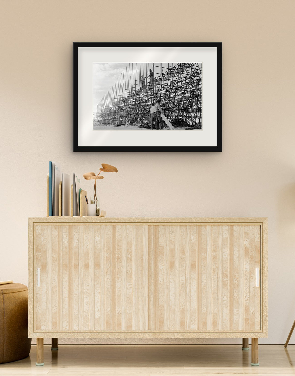 Fine art print of “Building the Autostrada del Sole, 1958” with black frame and mat, hanging in a living room above a sideboard