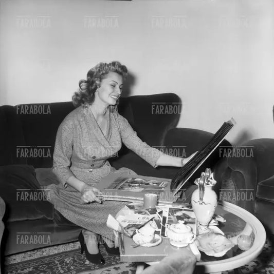 Sophia Loren sfoglia un album di fotografie a casa, Roma, 1954