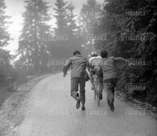 Un ciclista spinto da due tifosi sul Monte Bondone, Giro d'Italia, 1956