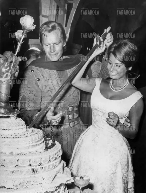 Sophia Loren e Charlton Heston tagliano la torta con la spada, Festa per la fine delle riprese del film El Cid, Roma, 1961