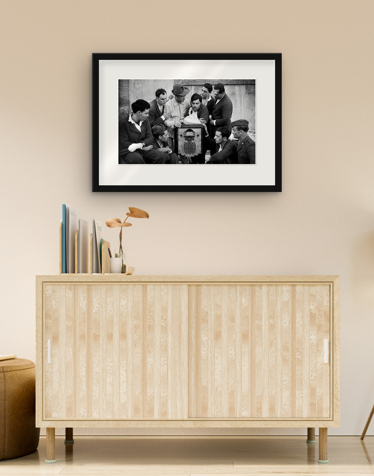 Fine art print of “Wounded soldiers listening to the radio, 1942” with black frame and mat, hanging in a living room above a sideboard