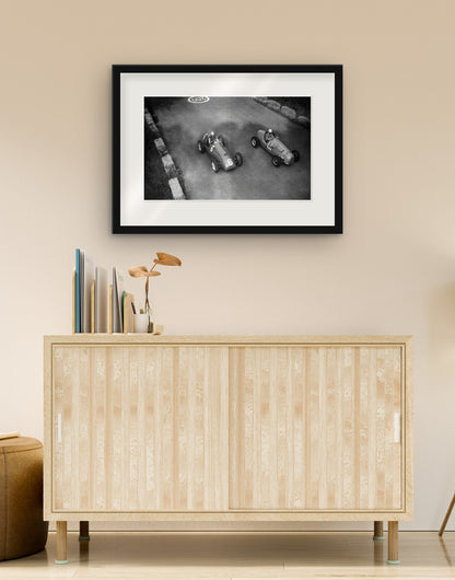Fine-Art-Druck von „Das Duell zwischen Ascari und Manzon, GP Monza 1951“ mit schwarzem Rahmen und Passepartout, im Wohnzimmer über einer Anrichte aufgehängt