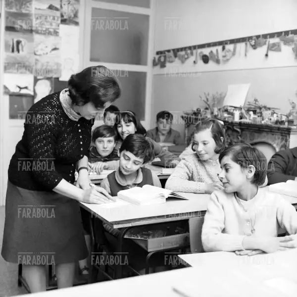 Maestra aiuta un alunno durante una lezione, Binasco, 1967 - Farabola Immagine digitale