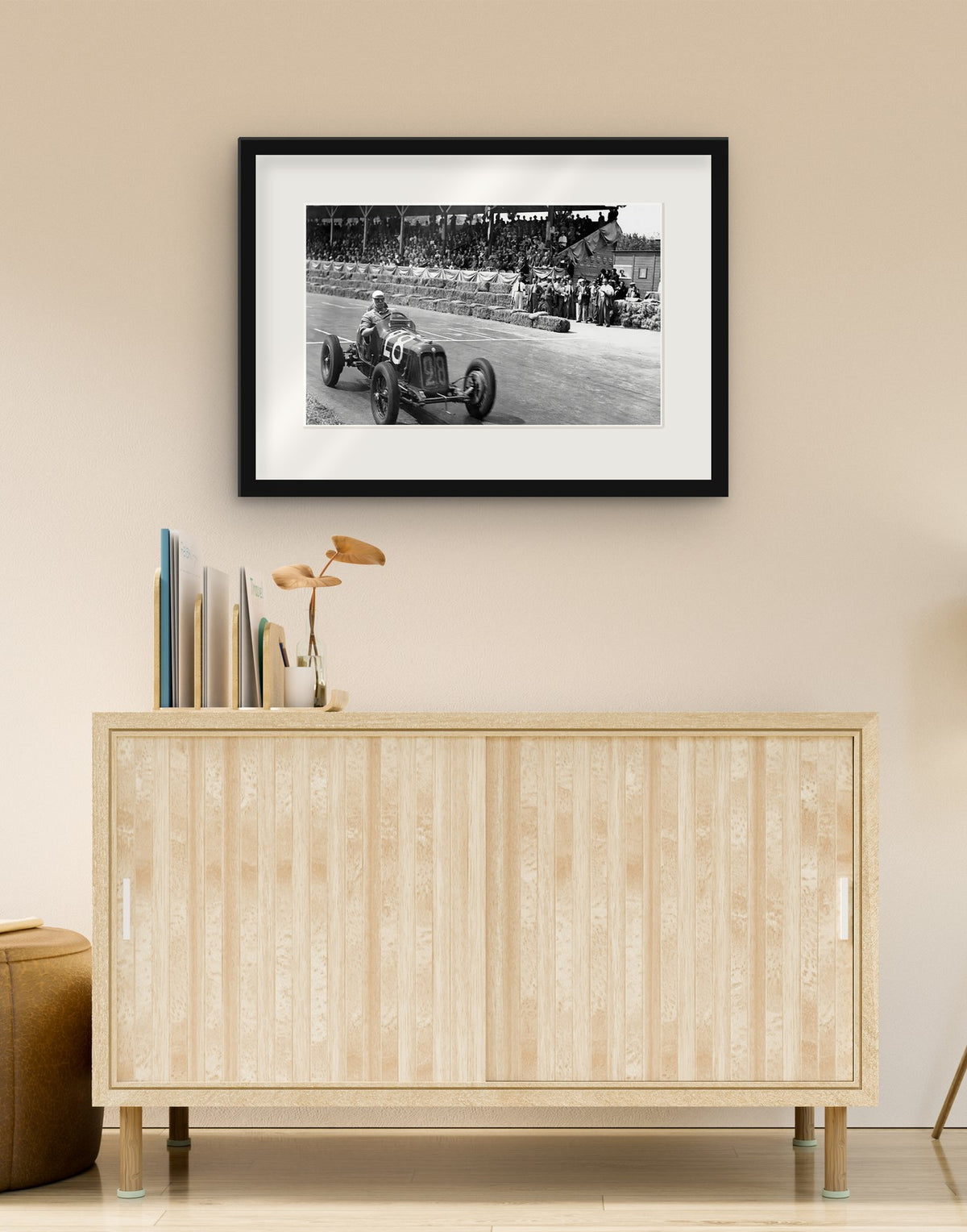 Stampa fine art di «Maserati sul circuito della Superba, Genova 1937» con cornice nera e passepartout, appesa in un soggiorno sopra una credenza