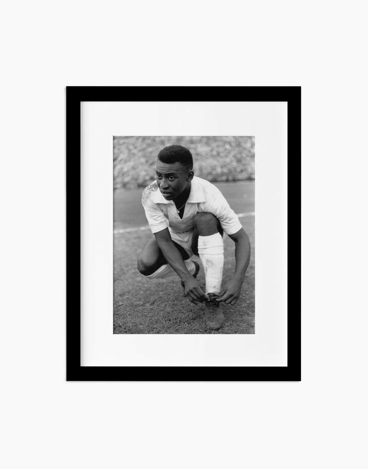 Pelè si allaccia le scarpe, Santos 1964 — stampa fine art con cornice nera