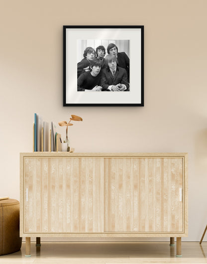 Fine-Art-Druck von „Die Rolling Stones, 1964“ mit schwarzem Rahmen und Passepartout, im Wohnzimmer über einer Anrichte aufgehängt